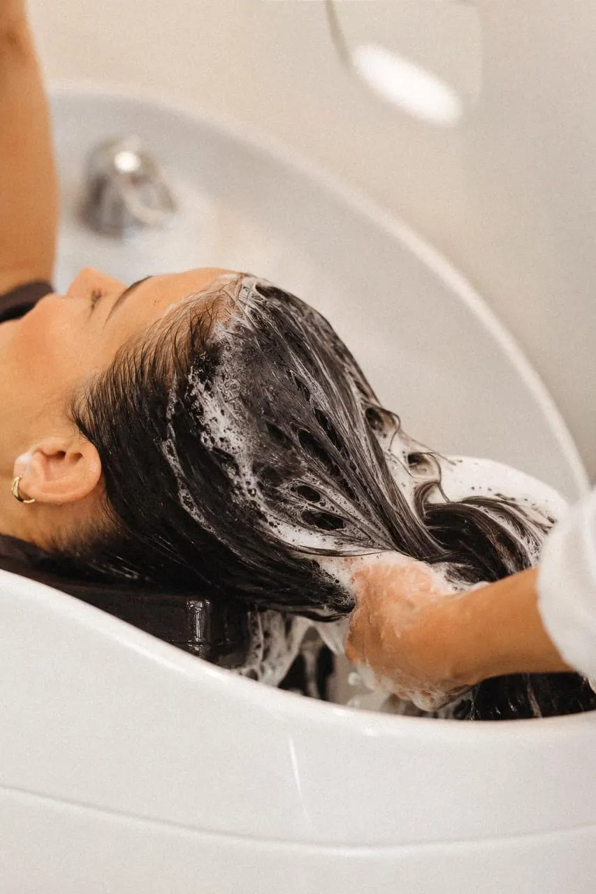 Cabelo sendo lavado com espuma no lavatório do DENIV